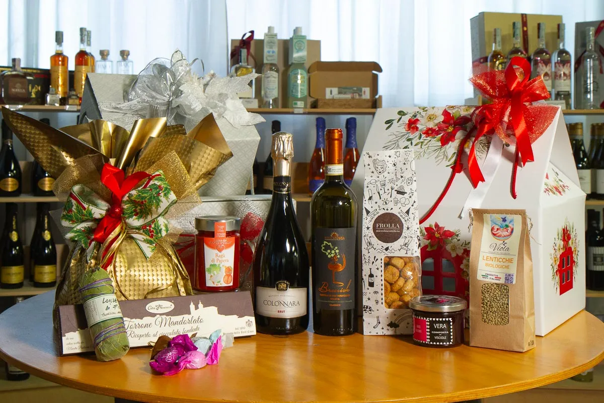 Un tavolo con i cesti di Natale, le bottiglie e i prodotti di una cantina