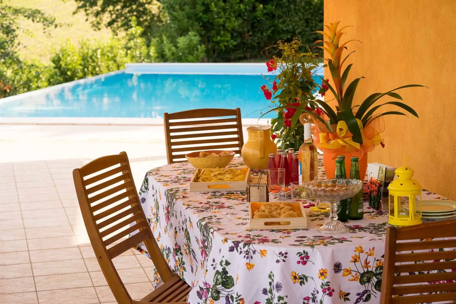 Una tavola per la colazione sotto un porticato, con la piscina sullo sfondo