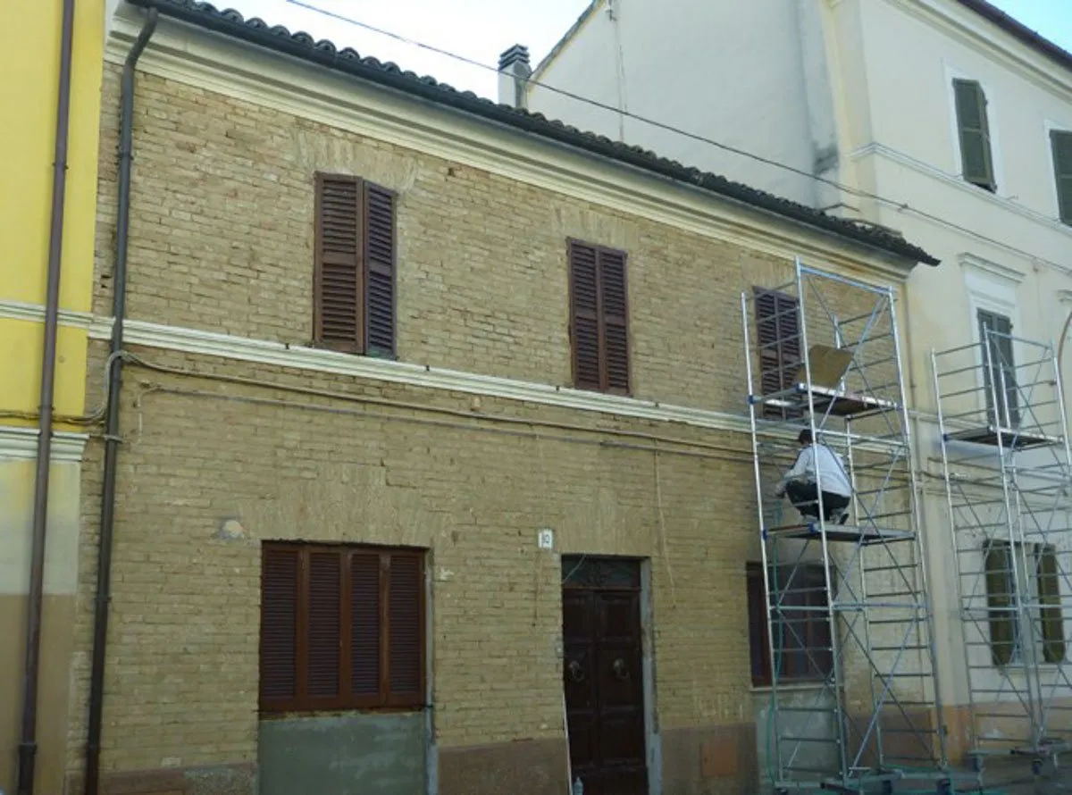 La facciata di un edificio con le impalcature, durante la valorizzazione