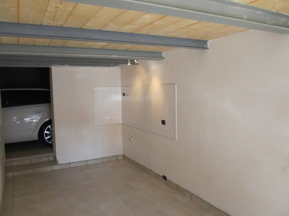 Un garage ristrutturato con le pareti bianche e il soffitto in legno