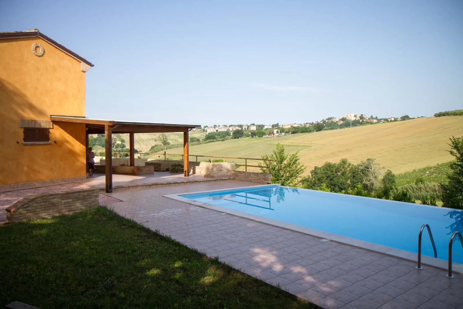 L'esterno di una casa in campagna con la piscina e le colline