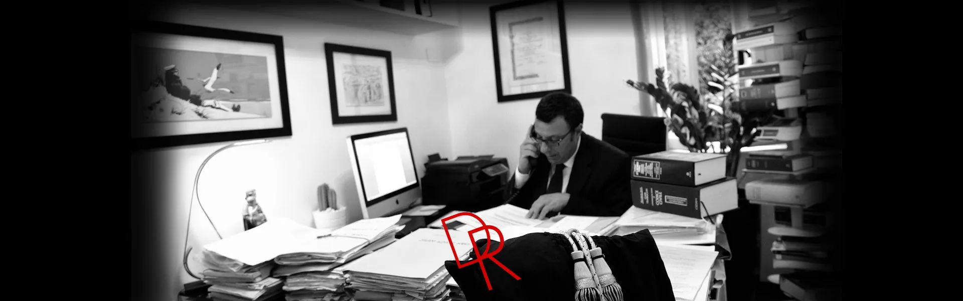L'avvocato Ramazzotti al telefono alla scrivania, in bianco e nero