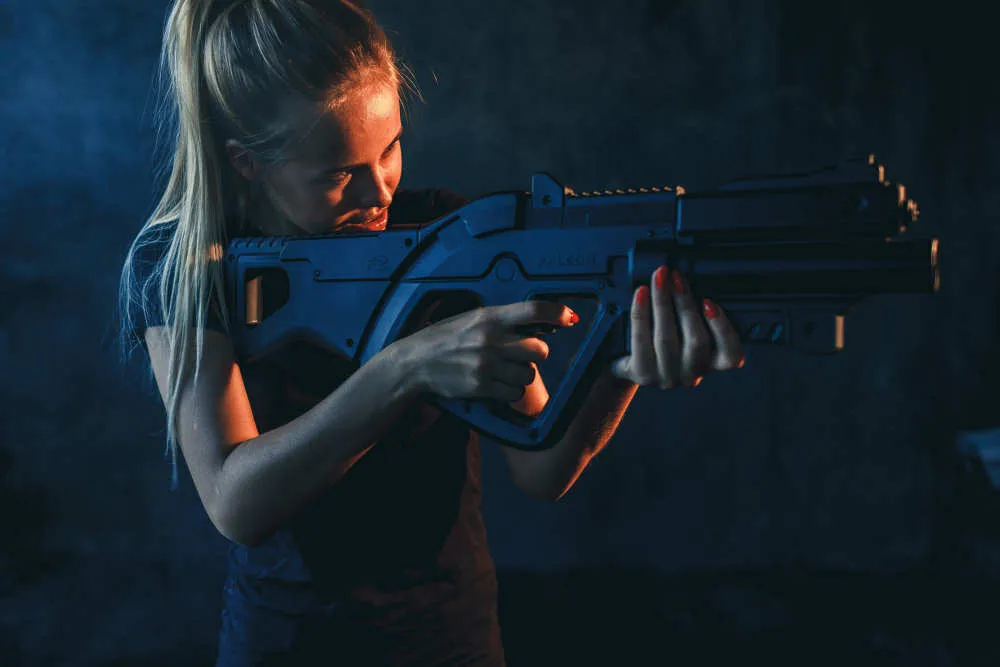Una giocatrice di laser tag con il fucile blu