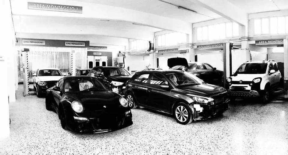 Il piazzale e le auto dell'officina in bianco e nero