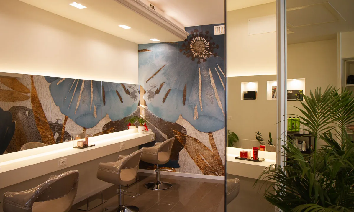 Postazioni del salone davanti alla parete con il fiore azzurro e oro