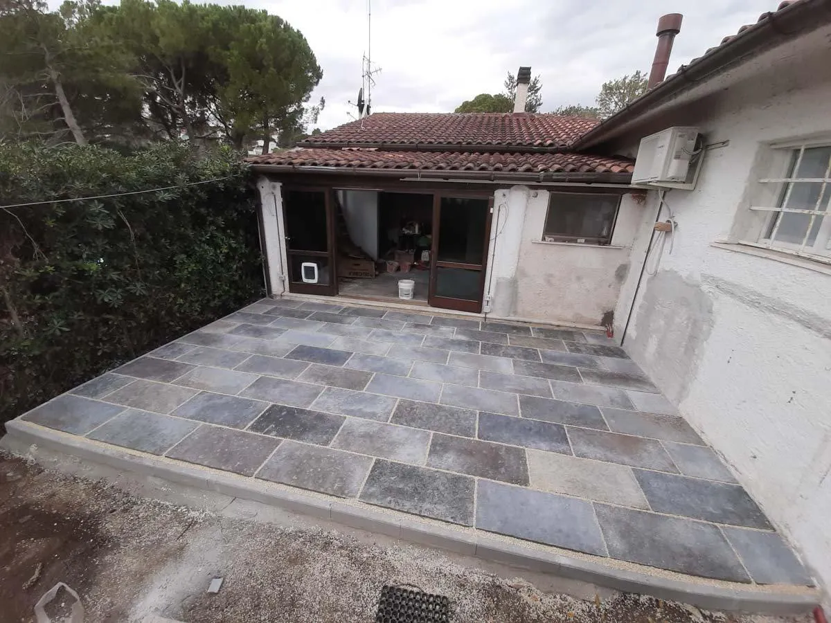 Un patio con la pavimentazione in lastre di pietra, finito