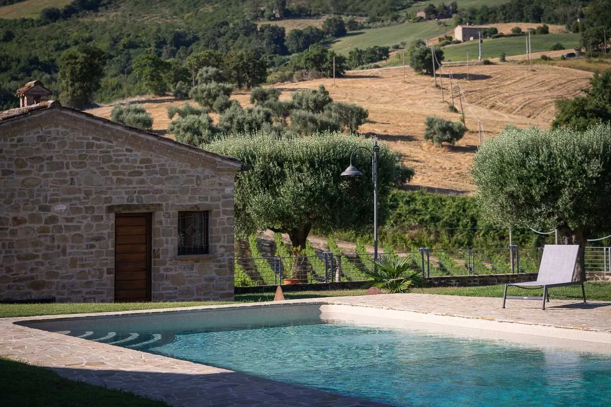 Un casolare in pietra con la piscina, tra gli ulivi e le colline