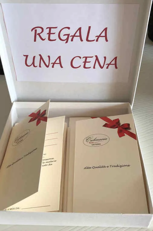 Una scatola con la scritta Regala una cena e il menù dell'osteria