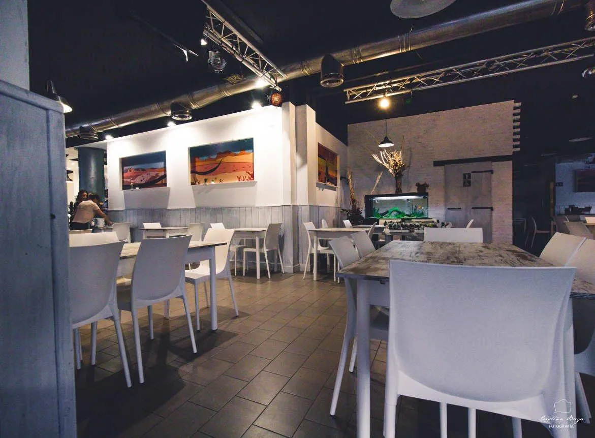 La sala del ristorante, con i tavoli bianchi e le luci a sospensione