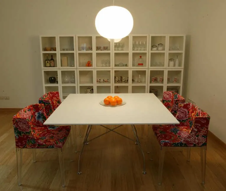 Una sala da pranzo con un grande tavolo bianco e una lampada rotonda