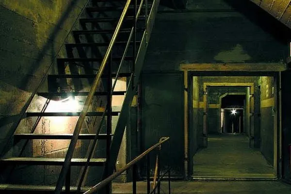 Una scala buia che scende in un corridoio, da una delle stanze