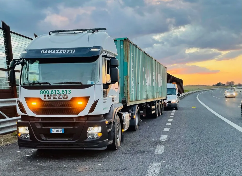 Un autoarticolato con container sulla strada al tramonto