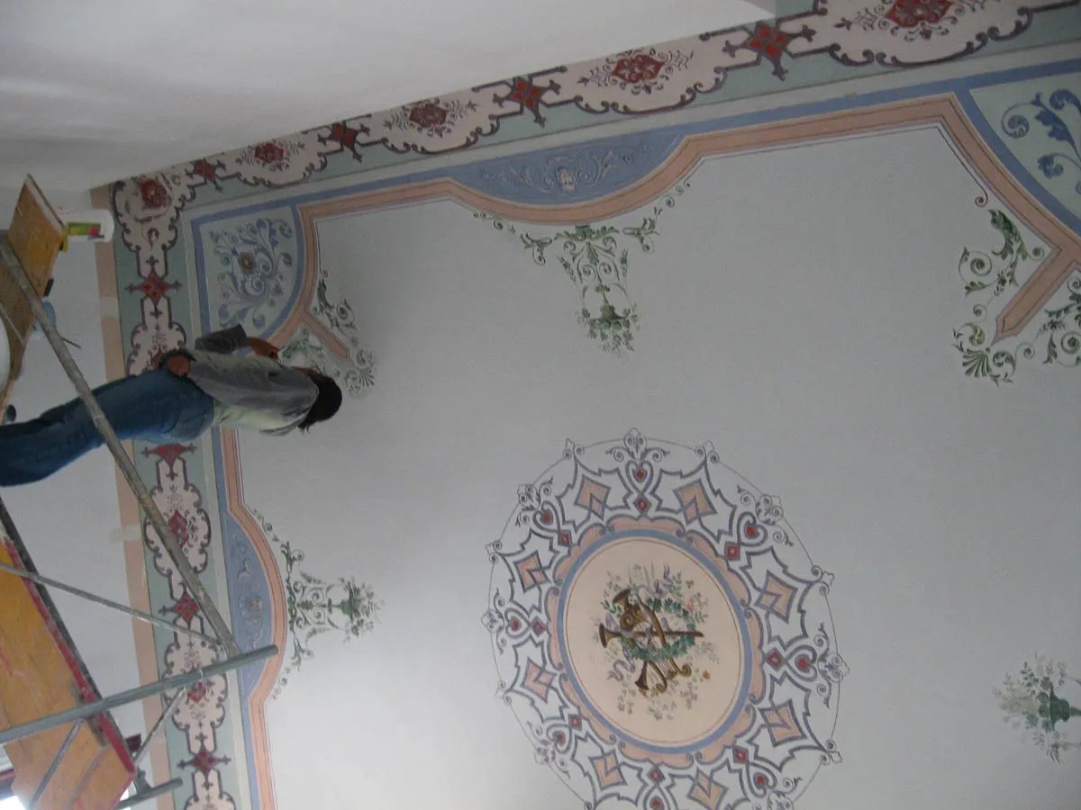 Un soffitto decorato a motivi floreali durante il restauro
