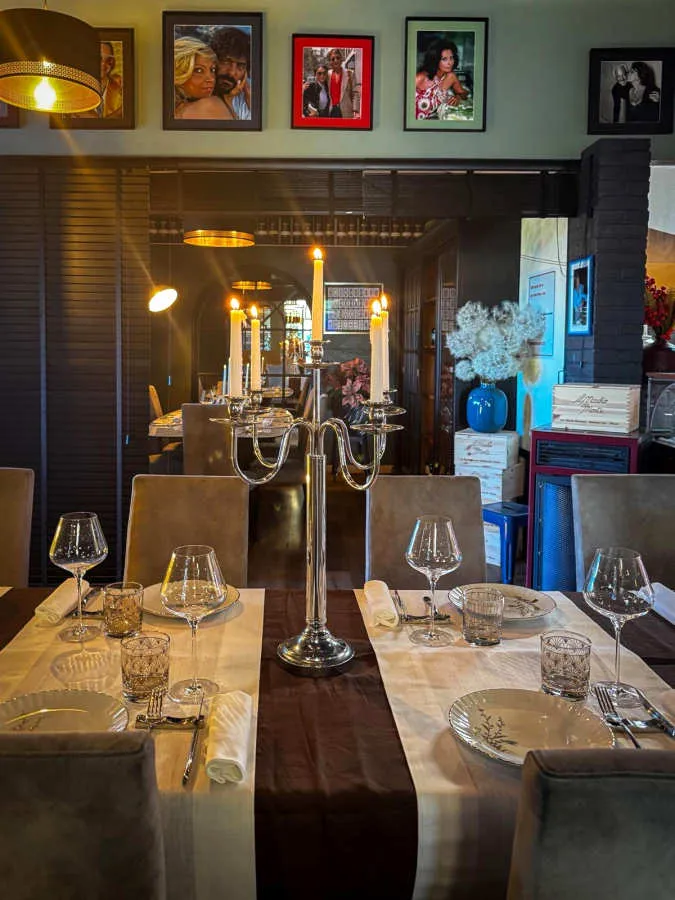 Una tavola apparecchiata con un candelabro, nella sala dell'osteria