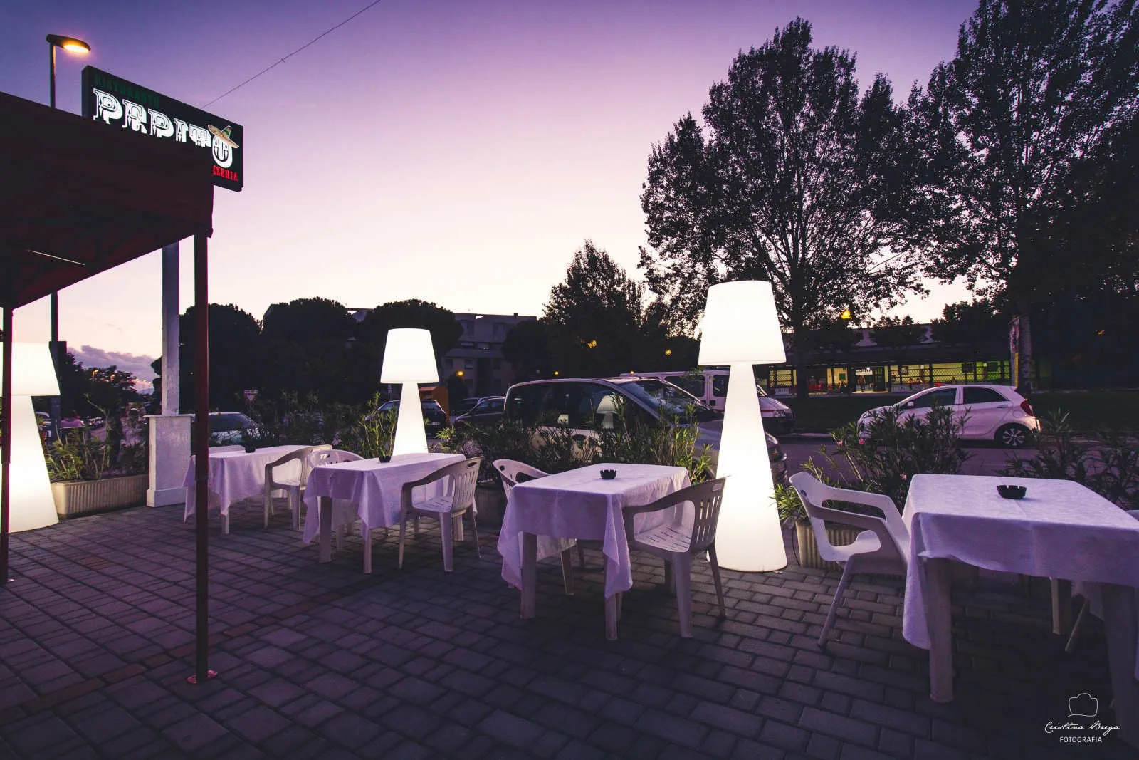 I tavoli apparecchiati sulla terrazza di un ristorante, al tramonto