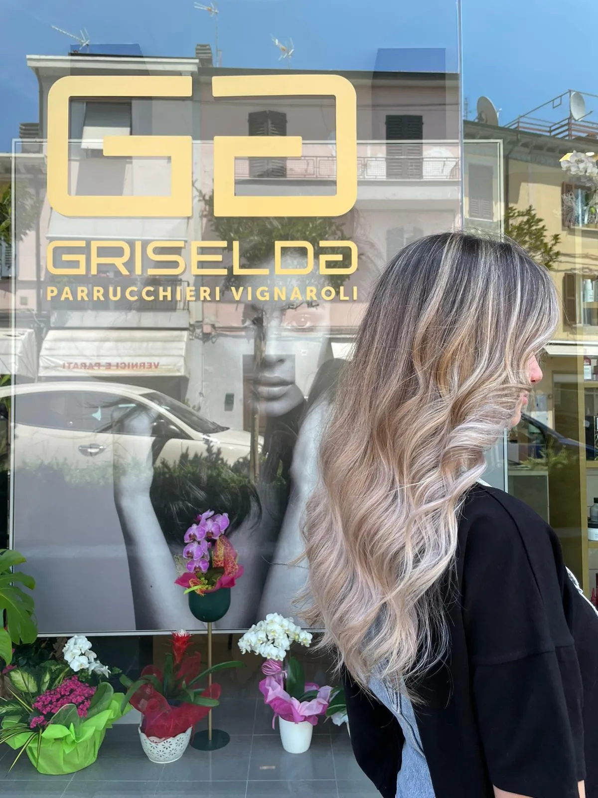 Vetrina del salone con il logo Griselda e il riflesso di una cliente